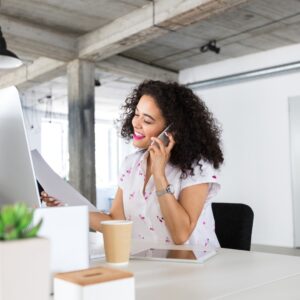 woman researching on computer and on the phone